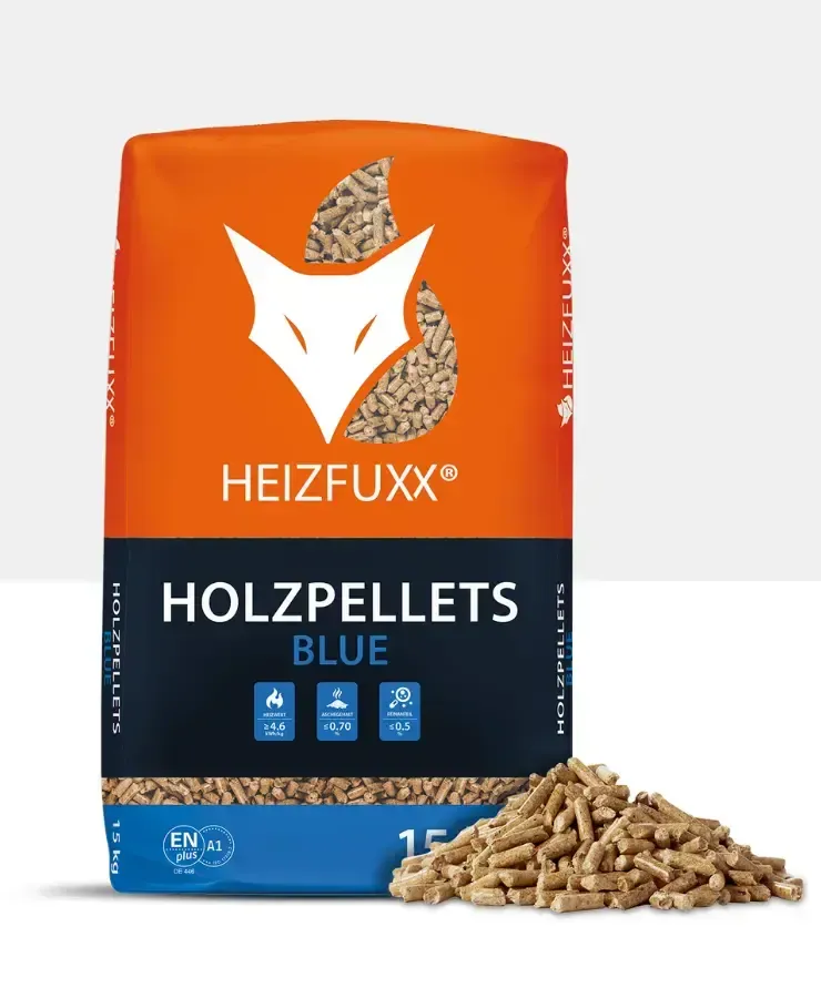 A 15 kg bag of Heizfuxx Holzpellets BLUE wood pellets, with loose softwood pellets beside the bag